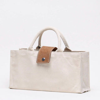 Oblique view of ShoreBags Natural Canvas wine tote with natural handles and Tan Leather Tab with snap.