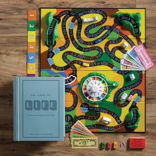 Fabric wrapped book with integrated storage with
Vintage inspired graphics from the original 1960 edition- Game of Life
Plastic spinner
3 Mountains, bridge and 7 buildings
6 plastic car pawns, people pegs
Money, insurance policies
Stock certificates and promissory notes
Deck of 24 cards
Betting board
