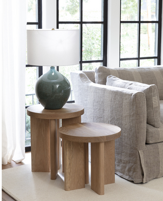Regina Andrew Fraya Side Table in solid white oak. Round table with four legs pictured with a lamp on it next to a sofa.
