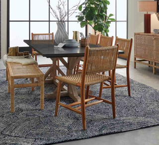 Made Goods Corenne teak dining chair. Danish design with natural woven fiber wrapped back and woven seat. View of chairs around a dining table.