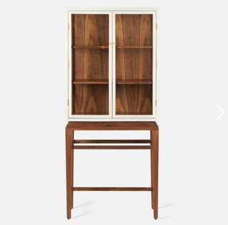 Made Goods Jamison Cabinet in pristine faux raffia and walnut veneer. Cabinet with glass dooes  in pristine faux raffia resting on tall walnut veneer legs. Front view.