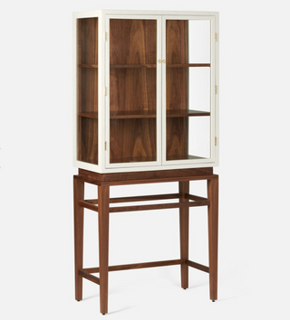 Made Goods Jamison Cabinet in pristine faux raffia and walnut veneer. Cabinet with glass dooes  in pristine faux raffia resting on tall walnut veneer legs. Front and side view.