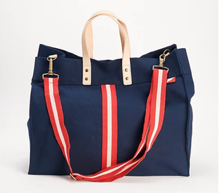 ShoreBags Navy tote bag with red and white adjustable strap and stripe down the middle. With natural tan handles.