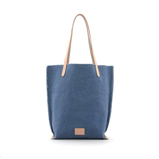 The Hana Tote shape makes a perfect casual bag. Extra strong for everyday use, with a sturdy vegetable-tanned leather to trim the base seams, strap and a nickel snap closure. Also features hand-frayed deconstructed edges and an interior pocket. Due to the artisanal and hand finished nature of the fraying technique you may experience loose threads that make their way out of the unfinished edges up until the stitching around the edge of the bag., with a sturdy vegetable-tanned leather to trim the base sea
