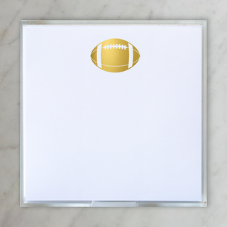 notepad with gold foil football centered on top of pad