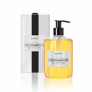 Clear plastic bottle of liquid soap with black pump and Lafco Label in front of a white Lafco box with faux grosgrain ribbon and Lafco label